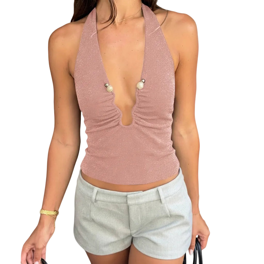 Person wearing a pink halter top and light shorts outdoors.